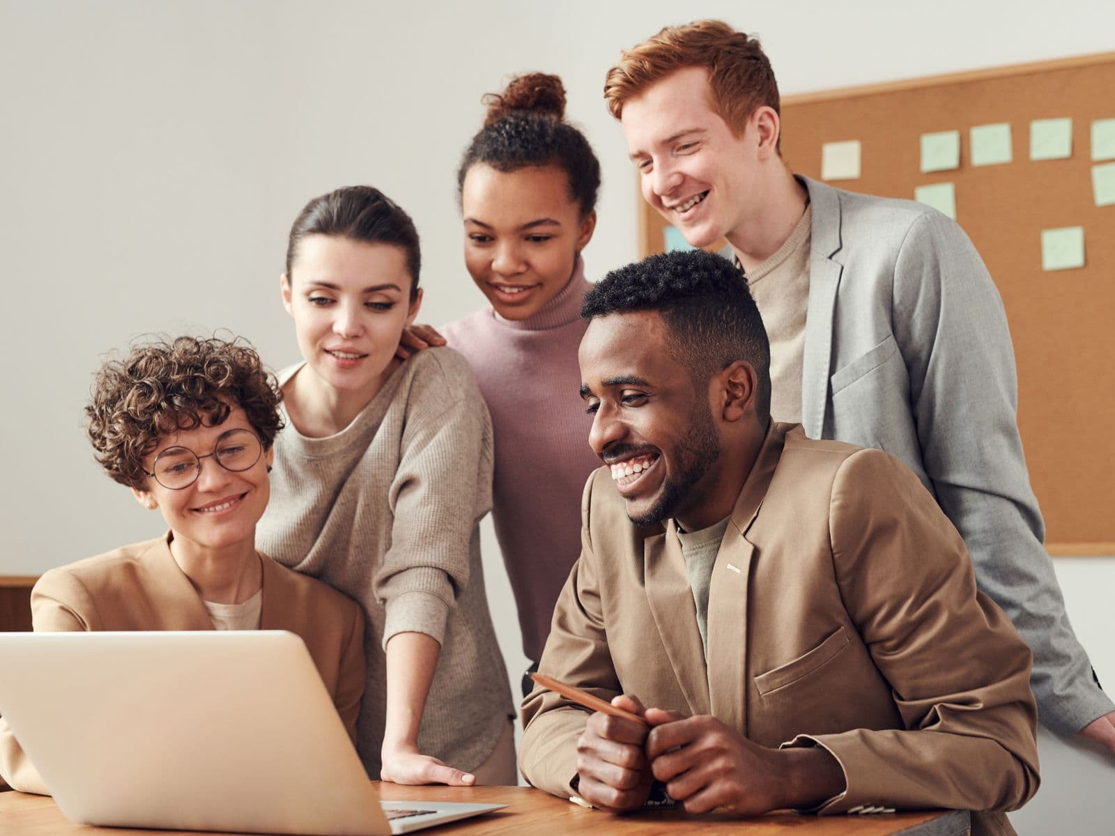 Equipe reunida em frente ao computador comemorando um resultado
